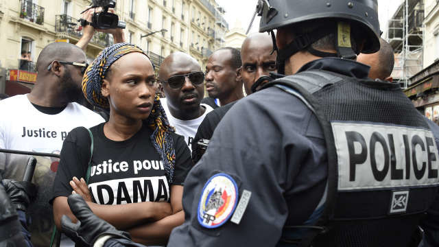 Adama's sister, Assa looks on in front of a French anti riot policeman as demonstrators take part in a march to protest at the death of Adama Traore in front of the Gare du Nord train station, in Paris, on July 30, 2016. The family of Adama Traore, died eleven days ago during his arrest, called for the "truth" today before a protest march in Paris, after justice rejected on July 29, 2016, the request of the family of Adama Traore to perform a third autopsy on the body of the young man who died last week during his arrest, said the prosecutor of Pontoise. (Photo by DOMINIQUE FAGET / AFP)