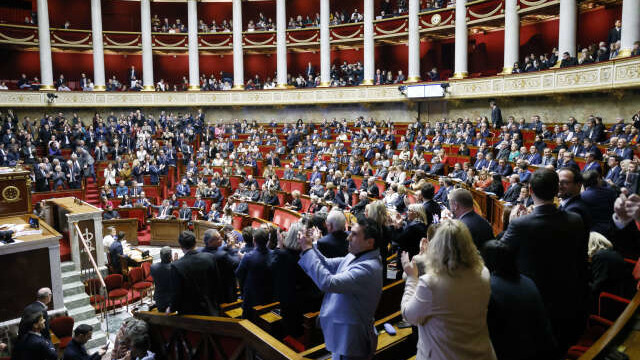 Members of Parliament react after the draft law to control immigration has been rejected at the National Assembly in Paris on December 11, 2023. The French lower house of parliament started to debate a bill seeking to tighten immigration rules criticised by both the far-right and hard-left in a major test for the government. (Photo by Ludovic MARIN / AFP)