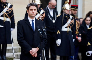 Newly appointed Prime minister Gabriel Attal listens to the speech of outgoing Prime minister Elisabeth Borne during the handover ceremony at the Hotel Matignon in Paris, on January 9, 2024. Gabriel Attal, named France's youngest ever prime minister on January 9 at the age of 34, has had a meteoric rise that has invoked comparisons with that of his mentor President Emmanuel Macron. (Photo by Ludovic MARIN / POOL / AFP)