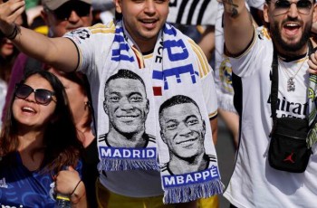 (FILES) Supporters wearing football scarves depicting French footballer Kylian Mbappe cheer prior Real Madrid's celebration for winning 2024 Spanish La Liga title at Cibeles square in Madrid on May 12, 2024. Kylian Mbappe has signed for Real Madrid, according to the club, AFP reports on June 3, 2024. (Photo by OSCAR DEL POZO / AFP)