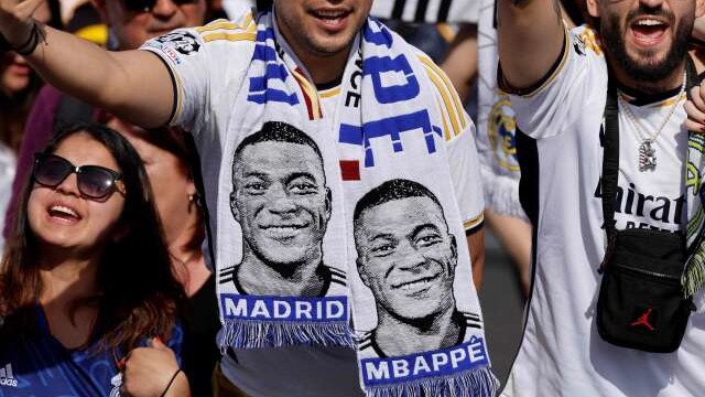 (FILES) Supporters wearing football scarves depicting French footballer Kylian Mbappe cheer prior Real Madrid's celebration for winning 2024 Spanish La Liga title at Cibeles square in Madrid on May 12, 2024. Kylian Mbappe has signed for Real Madrid, according to the club, AFP reports on June 3, 2024. (Photo by OSCAR DEL POZO / AFP)