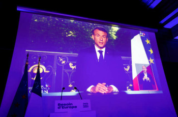 French President Emmanuel Macron appears on a screen following results after the polls closed in the European Parliament elections, in Paris, France, June 9, 2024. REUTERS/Abdul Saboor - RC2U78A12451